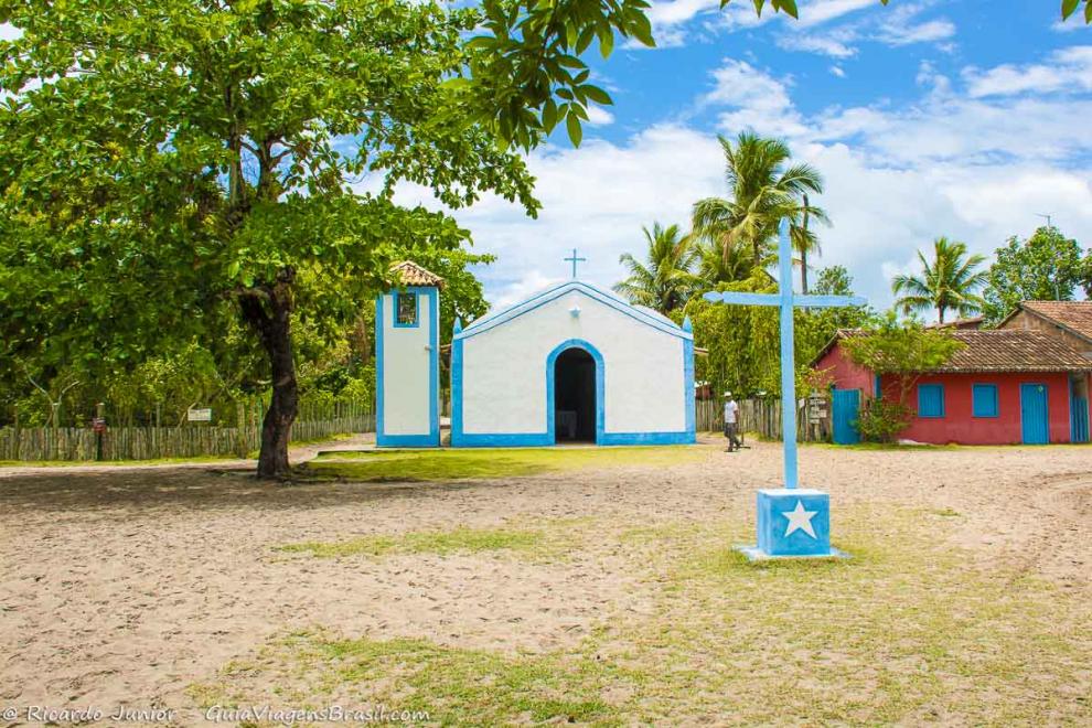 Imagem de um crucifixo em frente a igreja no vilarejo em Caraiva.